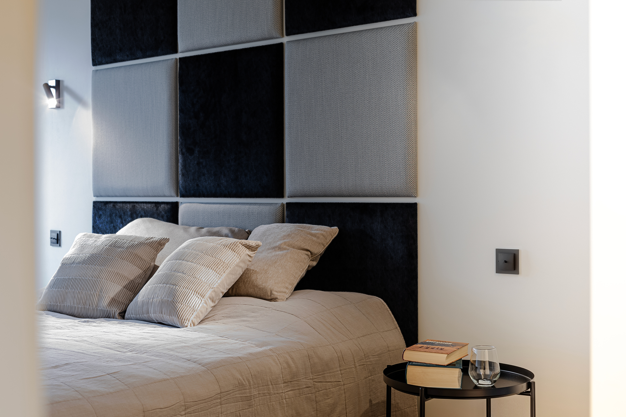 Tapicerowane panele na ścianie, pełnią rolę zagłówka, nie zabierając przestrzeni, w dosyć wąskiej sypialni.